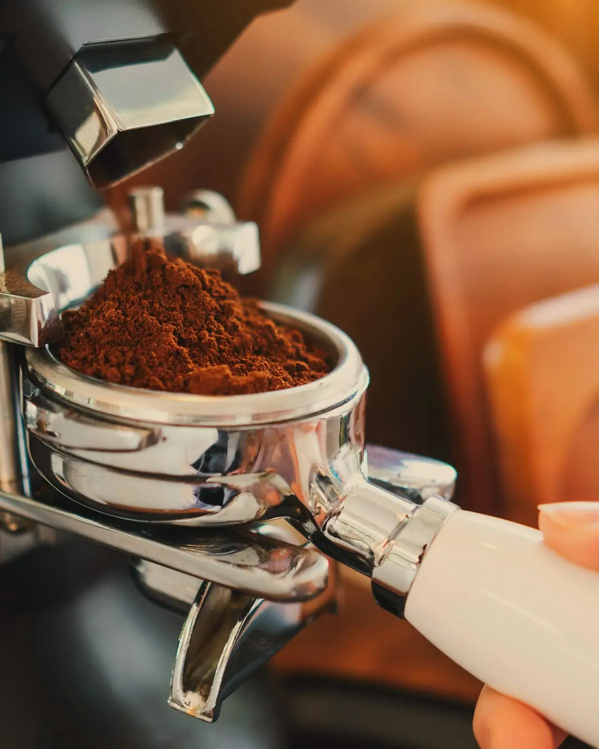 Râșnița umple portafiltrul cu cafea proaspăt măcinată